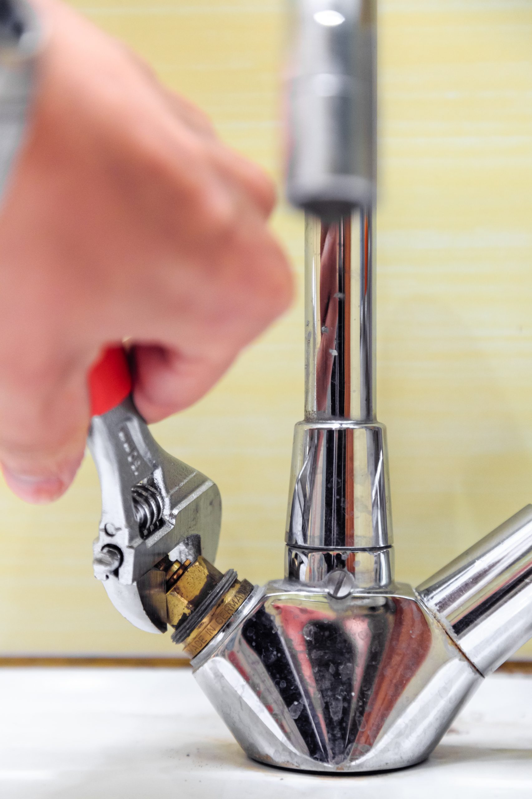 plumber tightening a sink tap